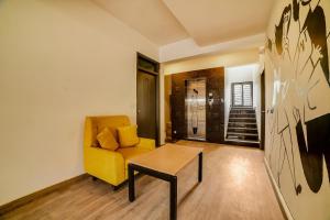 a living room with a yellow couch and a table at Townhouse Sarvar Hospitality Near Ascendas Park Square Mall in Bengaluru