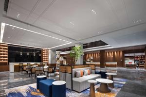 a lobby of a hotel with tables and chairs at Hilton Garden Inn Luoyang Kaiyuan Avenue in Luoyang