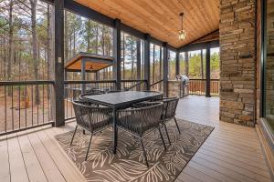 a screened porch with a table and chairs on it at Family Getaway, Hot Tub, Firepit! in Broken Bow