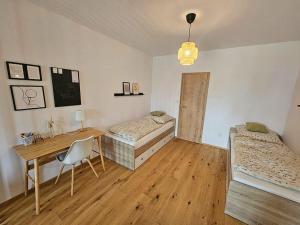 a room with two beds and a desk and a table at Benecko s terasou a s možností wellness 3475 in Benecko