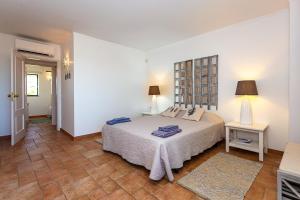 a white bedroom with a bed and a table at Nesha Cabanas Paradise in Tavira +63 photos