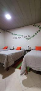 two beds in a room with a sign on the wall at Hosteria Felipa Pastor - Ex Munay Humahuaca in Humahuaca +22 photos