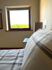 a bedroom with a bed and a window at Bluebell Cottage - Cedar Park in Grimsby