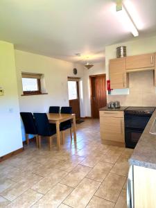 a kitchen with a table and chairs in a room at Bluebell Cottage - Cedar Park in Grimsby