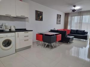 a kitchen and living room with a couch and a table at Néo Condo Jomtien Pattaya in Jomtien Beach