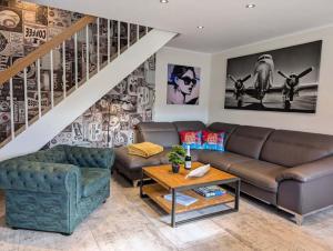 a living room with a couch and a table at Premium-Plus-Ferienhaus Havanna Select in Hasselfelde +19 photos