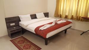 a bedroom with a large bed with a red blanket at Aquamarine Holidays Goa 2BHK Service Apartment 1 in Arpora