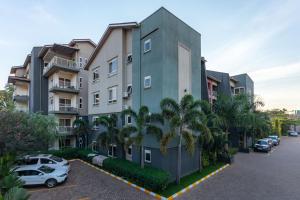 a building with cars parked in a parking lot at Natra Apartments in Kampala