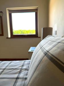 a bedroom with a bed and a window at Poppy Cottage - Cedar Park in Grimsby