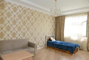 a living room with a couch and a bed and a window at Idea Park Apartment in Baku