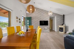 ein Esszimmer mit einem Holztisch und gelben Stühlen in der Unterkunft Villa Katarina in Labin
