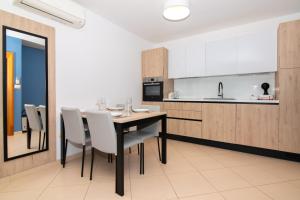 een keuken en eetkamer met een tafel en stoelen bij Garden Palace - Vitamin Sea Appartment with Teracce in Umag