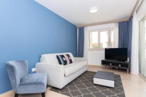 een woonkamer met een bank, een stoel en een tv bij Garden Palace - Vitamin Sea Appartment with Teracce in Umag