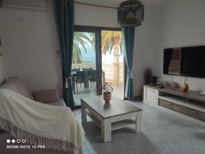 a living room with a couch and a tv and a table at Casa Rural La Vega in Alojera