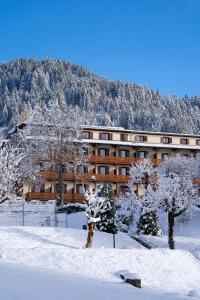 a building with snow covered trees in front of it at Villars Lodge in Villars-sur-Ollon
