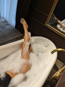 a duck laying in a bath tub with its legs in it at Park Gate apartment Новий Елітний ЖК біля Центрального парку in Chernivtsi