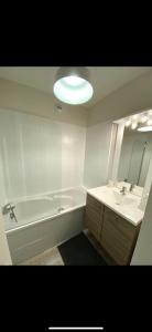 a bathroom with a tub and a sink and a mirror at Appart centre ville Orleans in Orléans +10 photos