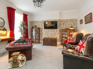 sala de estar con muebles de cuero y TV en Harbour Retreat, en Weymouth