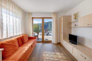 a living room with a couch and a television at Obertrisaierhof Wohnung 1 in Fie allo Sciliar