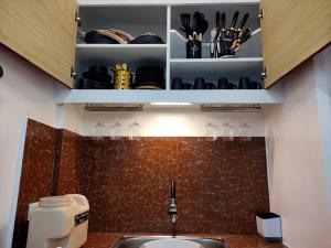 eine Küche mit einer Spüle und einer Theke mit Weingläsern in der Unterkunft SNOW Studio Apartment - Near Clark International Airport in Mabalacat
