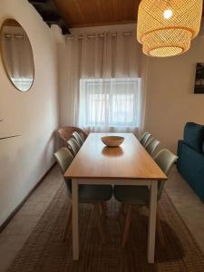 a dining room with a wooden table and chairs at Escapada amarela SPA et détente in Mariquiteira