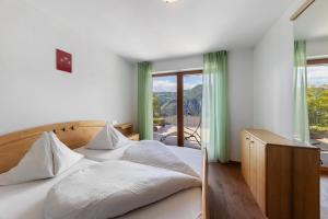a bedroom with two beds and a large window at Obertrisaierhof Wohnung 2 in Fie allo Sciliar
