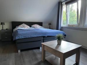 a small bedroom with a bed and a table at Carpe Diem met bar biljart en sauna in Lochem