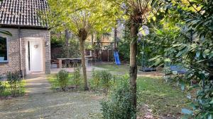 a garden with trees and a picnic table in the background at Carpe Diem met bar biljart en sauna in Lochem +7 photos