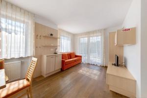 a living room with an orange couch and a table at Obertrisaierhof Wohnung 1 in Fie allo Sciliar