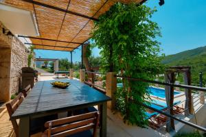 a table on a balcony with a view of a pool at Villa Eugenia by Briskva in Brseč