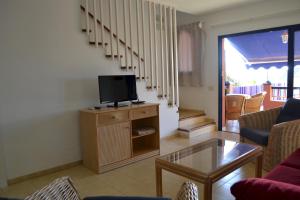 salon z telewizorem na drewnianej szafce w obiekcie Villa Meloneras - Exclusive Chill Out w mieście San Bartolomé