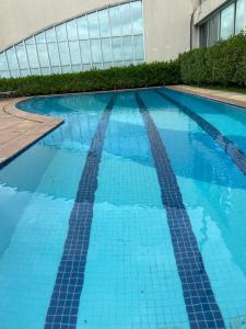 a swimming pool with blue tiles in front of a building at Flat BOUTIQUE em frente ao metrô MOEMA in Sao Paulo