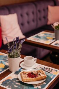 a plate of toast and a cup of coffee on a table at Vanilla Hotel in Lublin