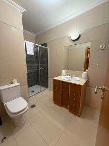 Un baño con inodoro, lavabo y ducha. en Casa de Férias Lucena, en Lourinhã 14 fotos más