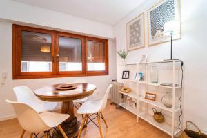 a dining room with a table and white chairs at Authentic Alicante Central Flat near the Beach in Alicante