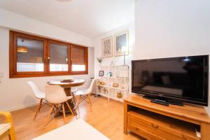 a living room with a large television and a table at Authentic Alicante Central Flat near the Beach in Alicante