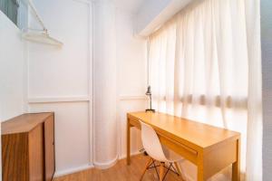 a wooden desk with a chair next to a window at Authentic Alicante Central Flat near the Beach in Alicante +24 photos