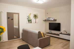 a living room with a couch and a flat screen tv at Mamma Nunzia in Alberobello
