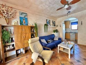 a living room with a blue couch and a table at Tu casita de la playa in Santa Pola
