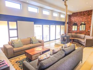 a living room with two couches and a tv at Highland Peace Haven In Dullstroom in Dullstroom