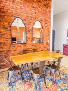 a table and chairs in a room with a brick wall at Highland Peace Haven In Dullstroom in Dullstroom