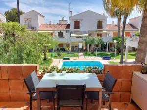 a patio with a table and chairs and a swimming pool at Tu casita de la playa in Santa Pola