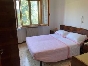 a bedroom with a bed with a pink blanket and two windows at B&B La cicala in Ascoli Piceno
