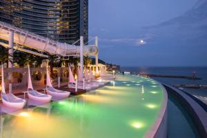 a swimming pool with lights on the side of a building at 2 minutes run to the sea only 152m, special benefit of Spa Waterpark 195m away in Busan