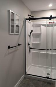 a sliding glass shower door in a bathroom at Newly Renovated Acadia Apartment Mple Street in Ellsworth