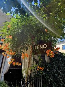a sign for a hotel with flowers on a fence at Hotel RENO on Deribasovskaya in Odesa