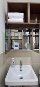 une salle de bain avec un lavabo et une étagère avec des serviettes dans l'établissement Hideouts & Hangouts, à Manille