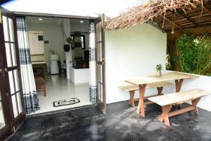 a patio with a wooden table and a bench at Homeaway Guesthouse in Hikkaduwa