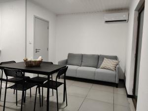 a living room with a couch and a table and chairs at Ocean View Cedros in Santa Cruz das Flores