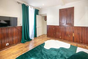 a room with wood paneling and a flat screen tv at Le Refuge du Val - Appartement vue montagne in Merlas